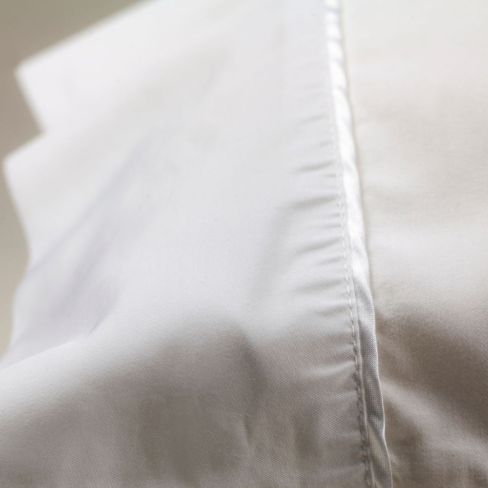 Nollapelli single white pillowcase close up on white satin trim